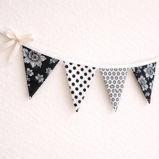 Close up of black and white fabric bunting banner showing scalloped zig-zag flag edges and cotton bias binding handmade nursery decor