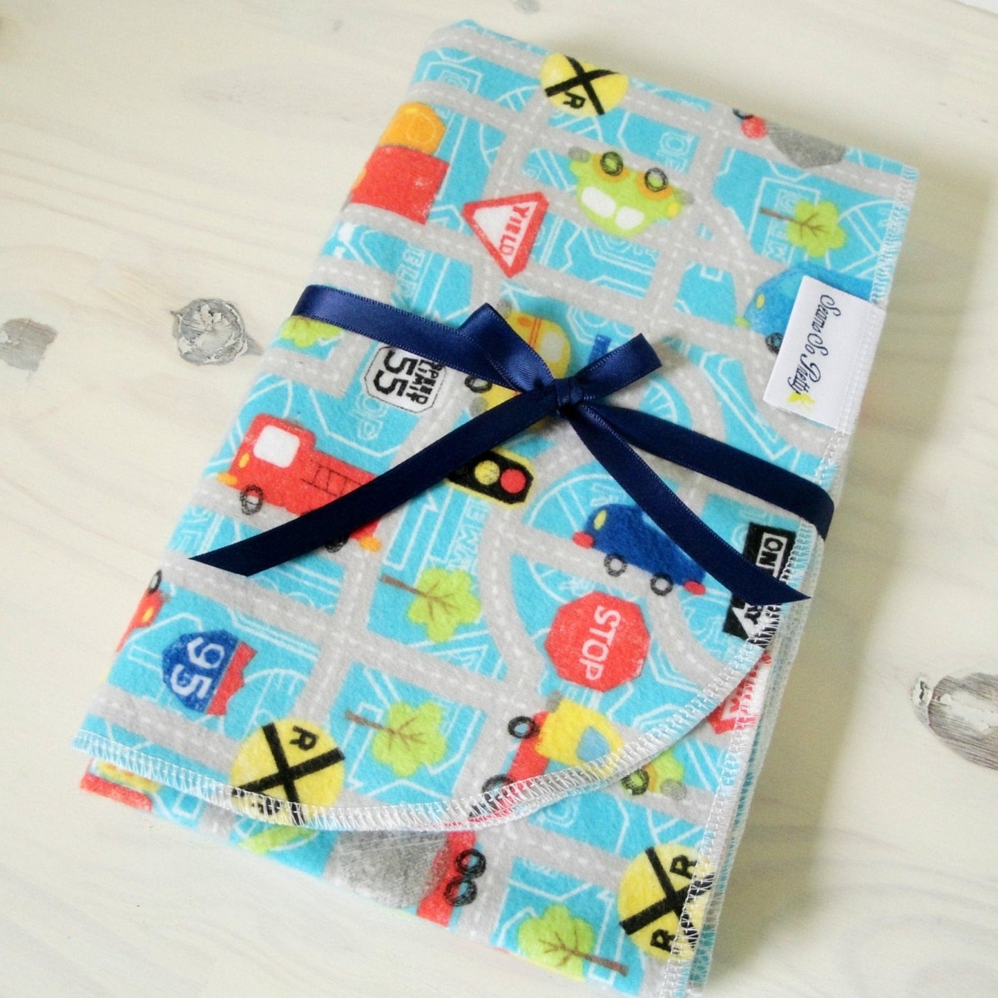 Cars, trucks and Road Signs flannel receiving blanket tied with blue ribbon bow rounded corner