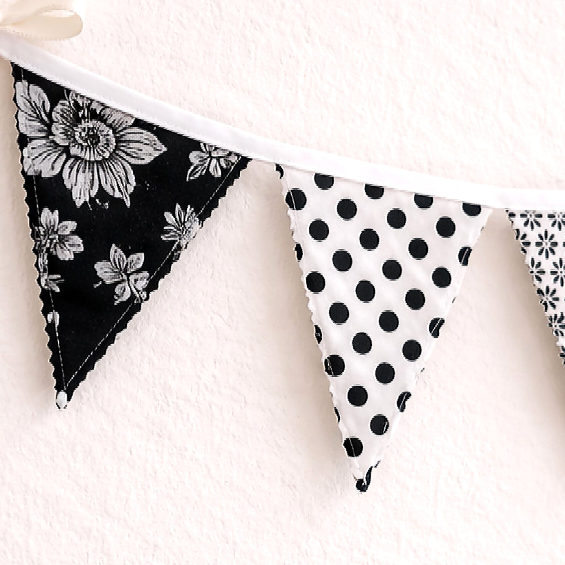 Close up of black white floral fabric bunting banner showing zig zag stitched edge and cotton binding detail