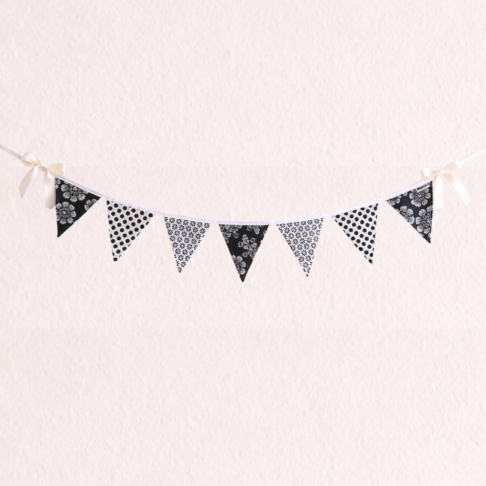 Black and white floral and polka dot fabric bunting banner with scalloped zig zag edges and cotton binding nursery wall decor