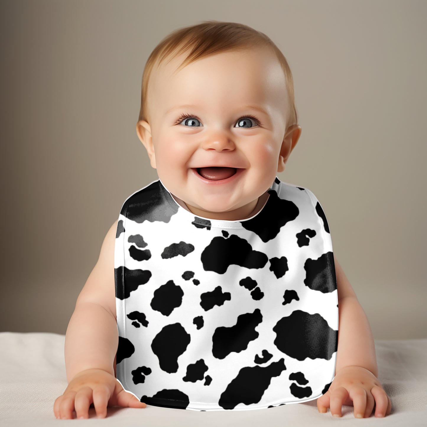 Smiling baby wearing cow print bib