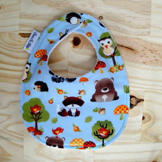Baby bib with animal pattern on a wooden surface
