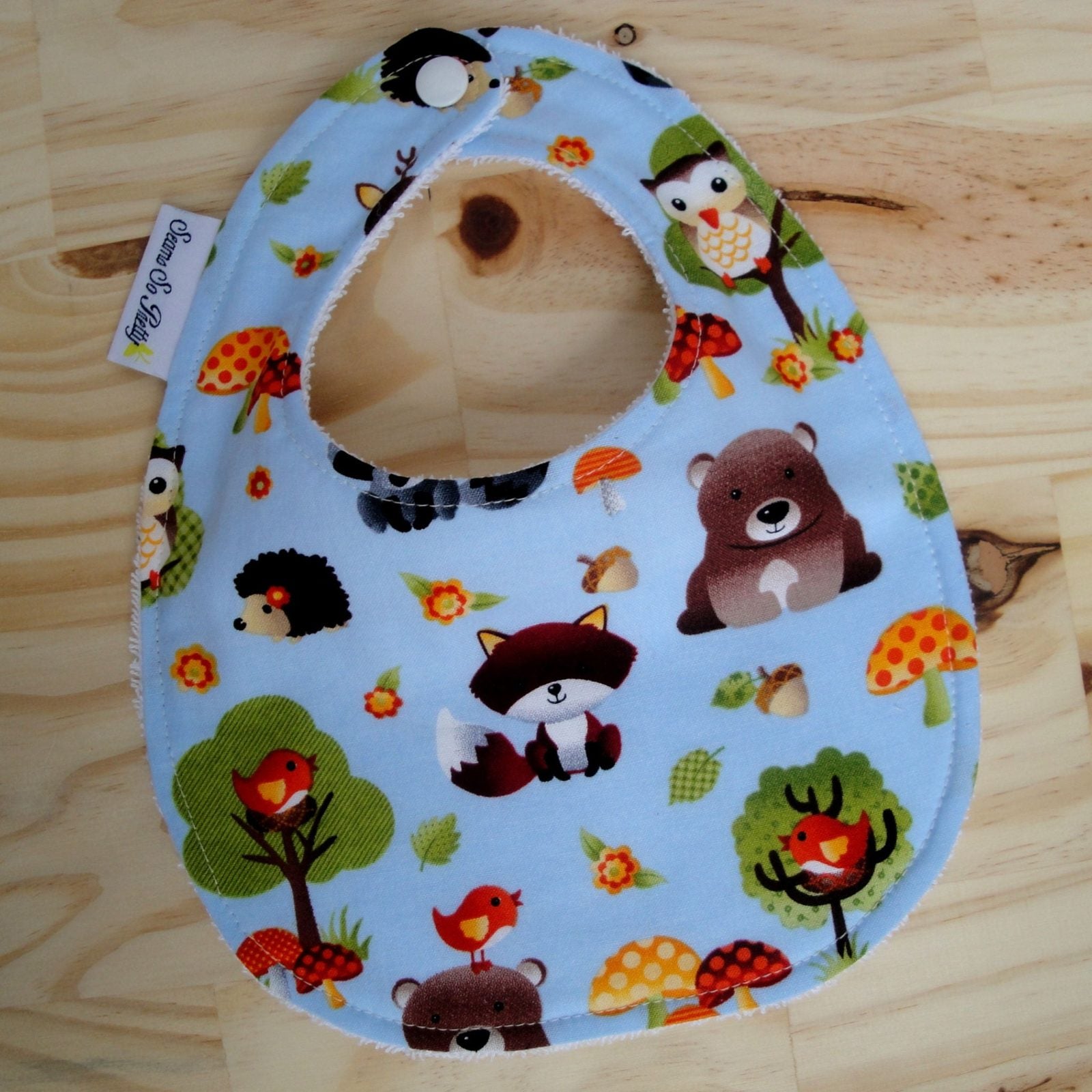 Children's bib with animal pattern on a wooden surface