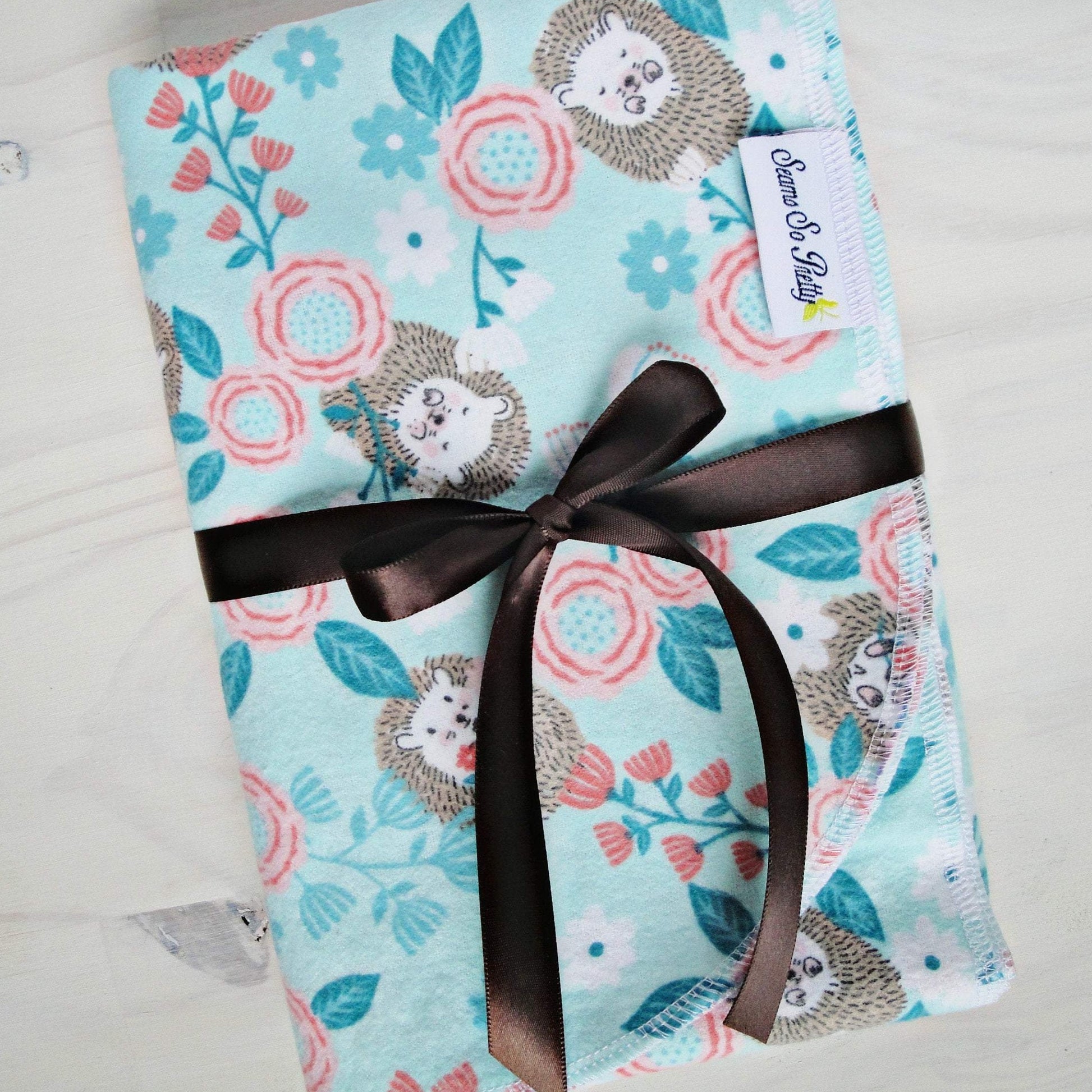 Brown Baby Hedgehog Coral Floral Flannel Receiving Blanket wrapped with brown ribbon