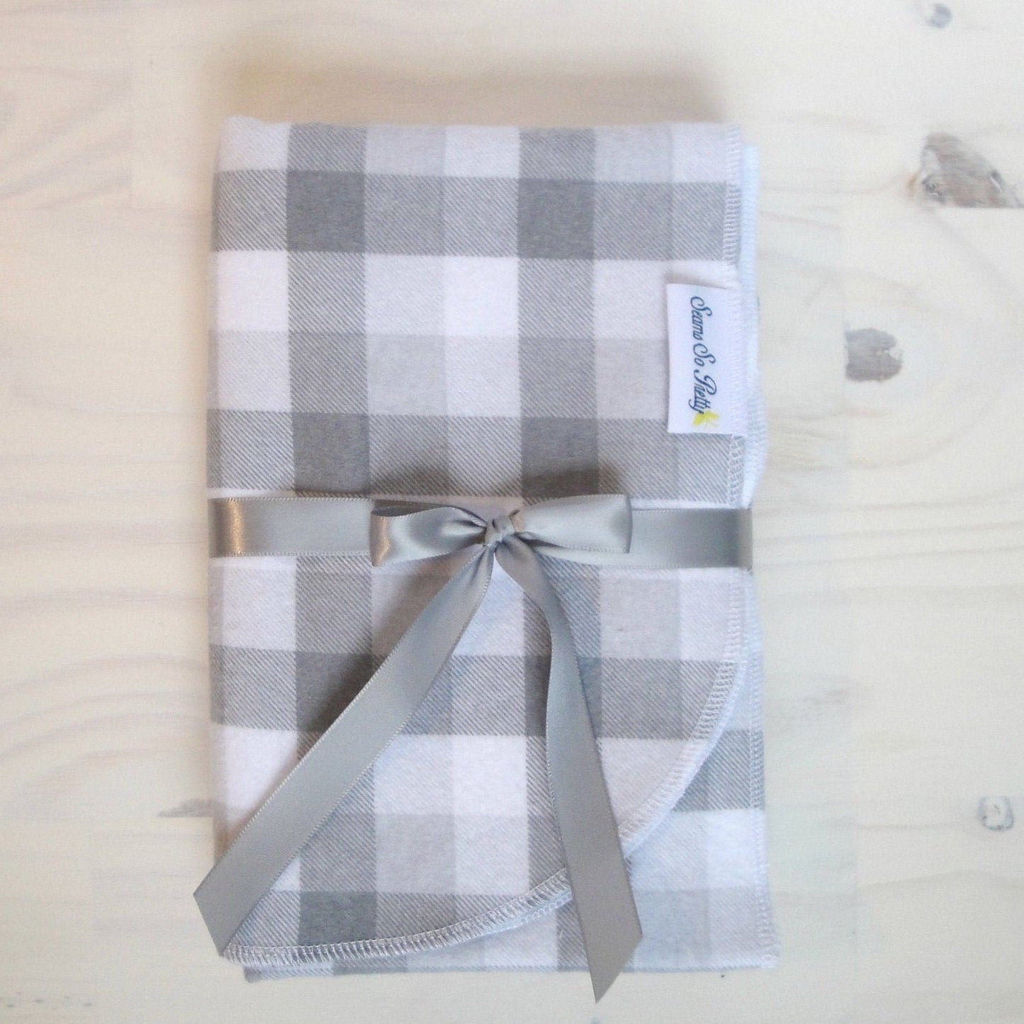 Gray and White Buffalo Check Flannel Blanket Folded with gray ribbon bow