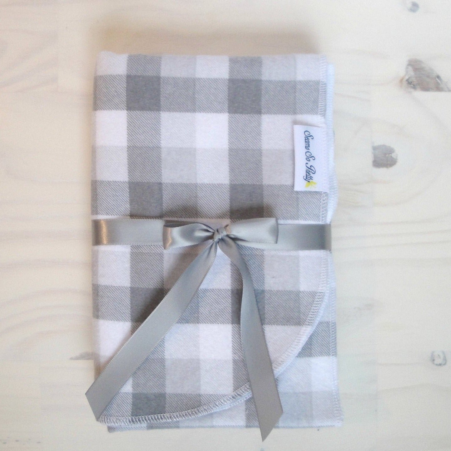 Gray and White Buffalo Check Flannel Blanket Folded with gray ribbon bow