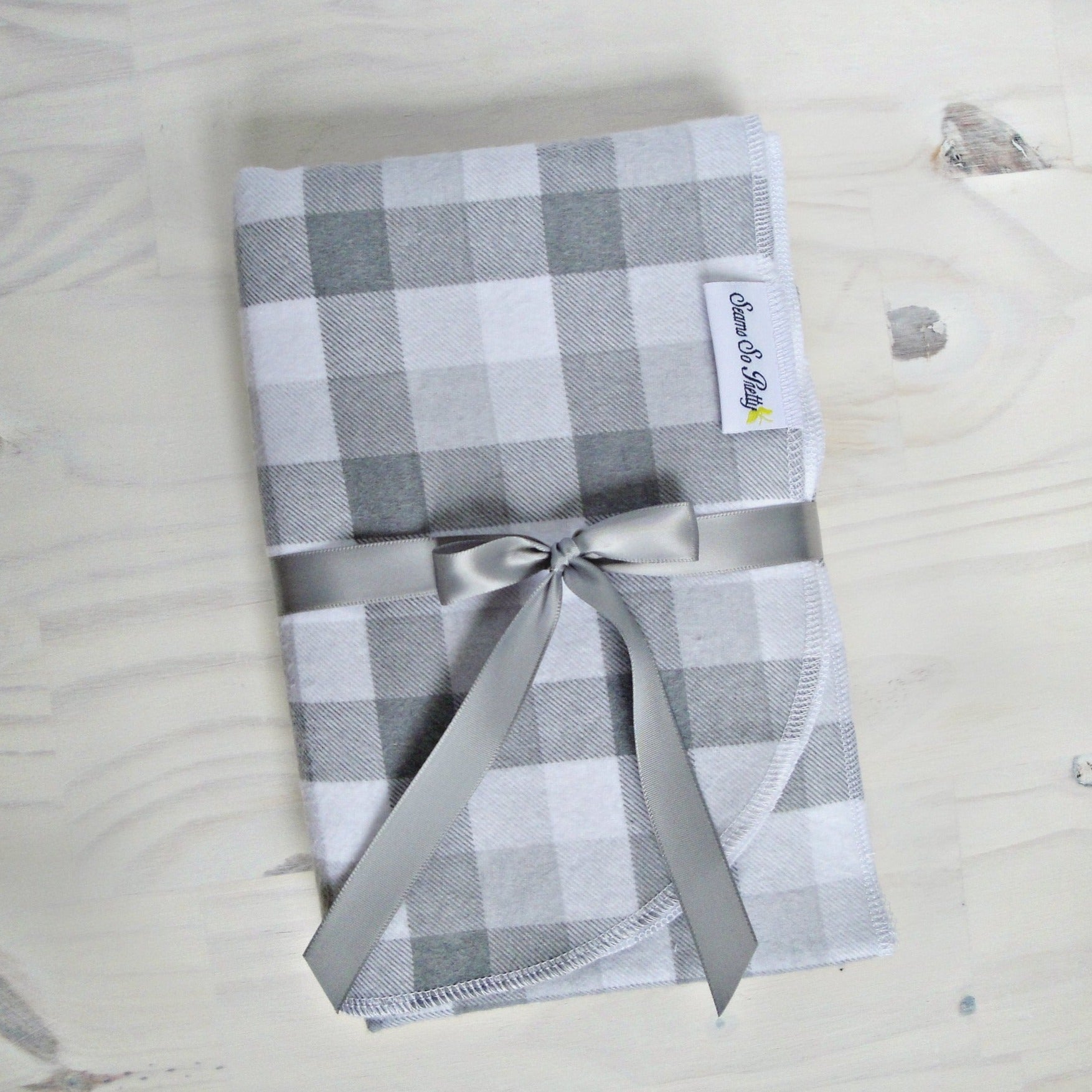 Gray and White Buffalo Check Flannel Blanket Folded with gray ribbon bow
