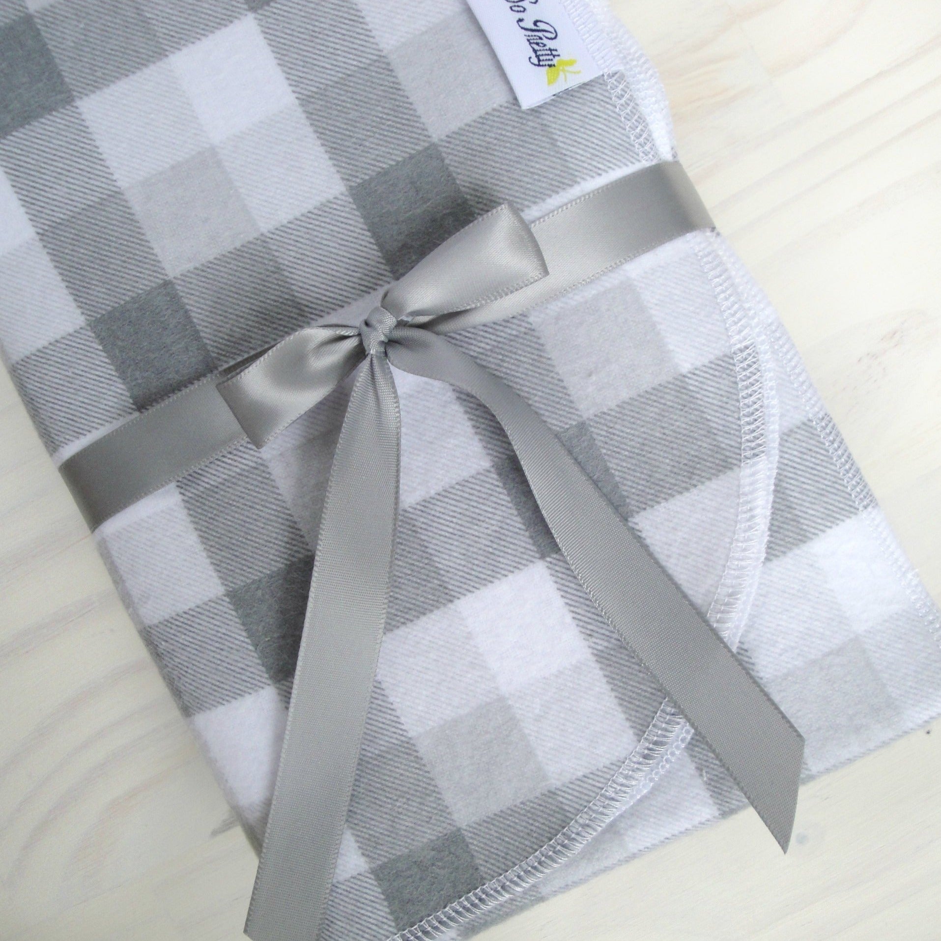 Gray and White Buffalo Check Flannel Blanket Folded with gray bow rounded corner